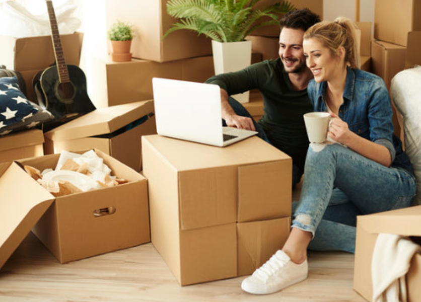 A smiling couple sits on the floor surrounded by moving boxes during a Nottingham house move A smiling couple sits on the floor surrounded by moving boxes during a Nottingham house move