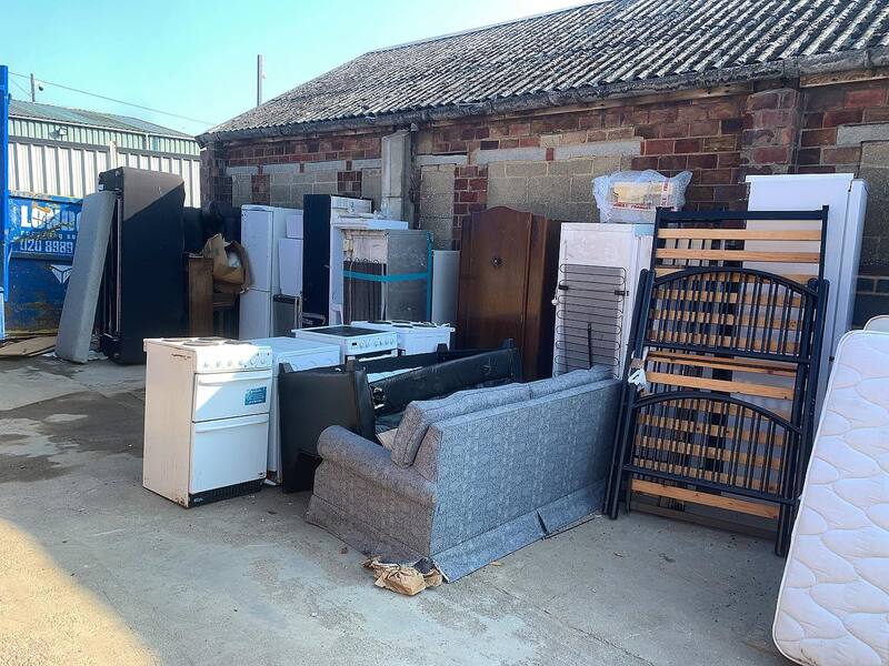 Furniture items bought back and stacked outside during a clearance